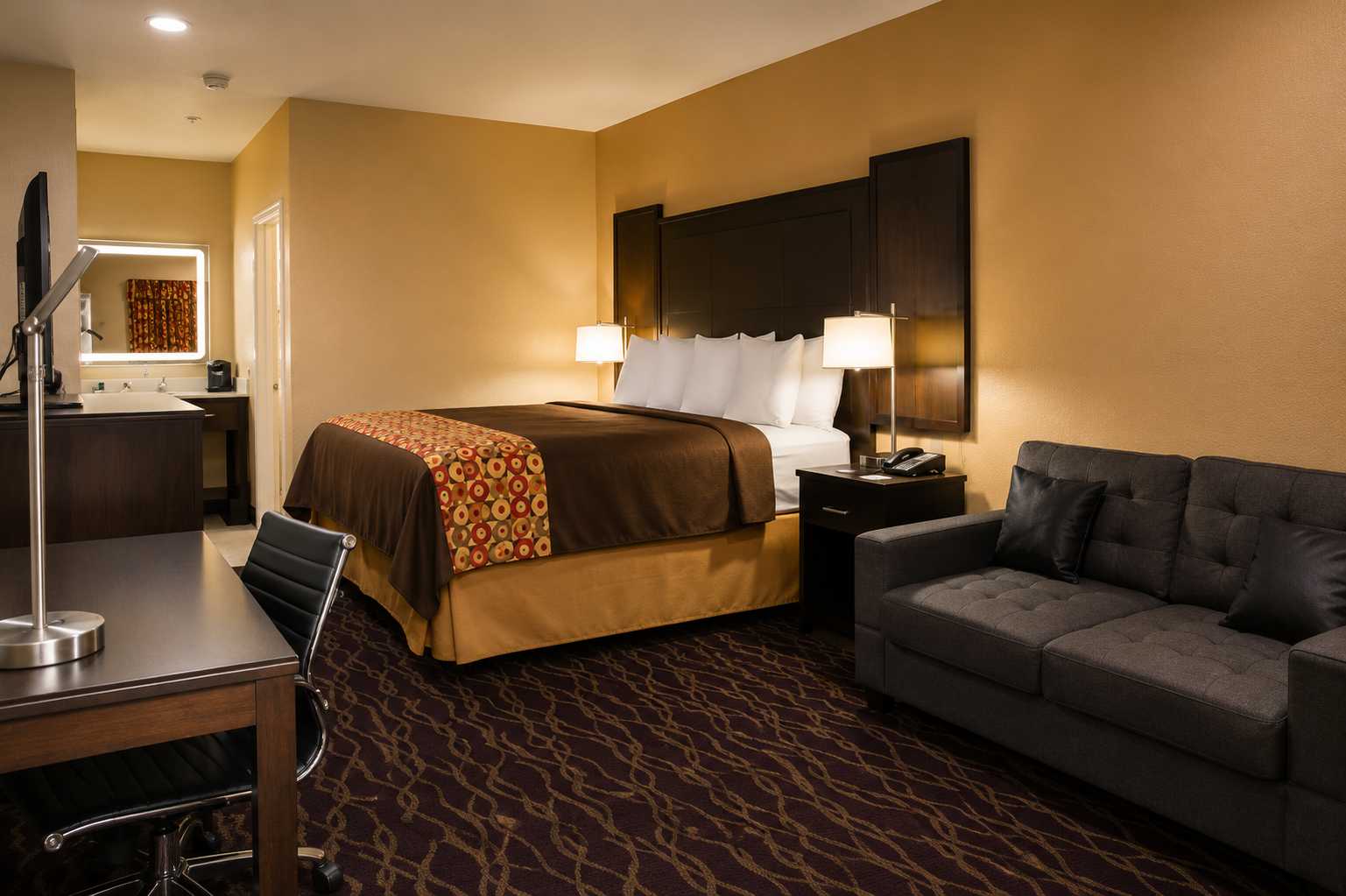 Deluxe King room with one extra-large double bed and warm lighting
